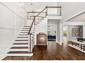 Inviting foyer with hardwood floors, paneled walls, staircase, and views to the living room at 5980 Mallet Ct, Cumming, GA 30040