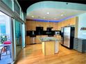 Stylish kitchen featuring stainless steel appliances, an island with bar seating, and a door to the balcony at 943 Peachtree Ne St # 1603, Atlanta, GA 30309