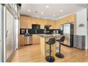 Modern kitchen with stainless steel appliances, black tile backsplash, an island, and access to a private balcony at 943 Peachtree Ne St # 1603, Atlanta, GA 30309