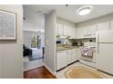 Well-lit kitchen with white cabinetry, modern appliances, and a view into a living area at 300 Johnson Ferry Ne Rd # A313, Atlanta, GA 30328