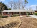 Charming brick home featuring a long driveway, carport, and landscaped yard at 1421 Downs Sw Dr, Atlanta, GA 30311