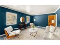 Bright living room with blue walls, large windows, and modern furniture at 1421 Downs Sw Dr, Atlanta, GA 30311