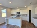 Modern kitchen with white cabinets, granite countertops, stainless steel appliances, and island with sink at 2724 Mourning Dove Drive Lot 32, Grayson, GA 30017