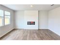 Bright, open living room with wood-look flooring, fireplace with white shiplap surround, and large windows at 2724 Mourning Dove Drive Lot 32, Grayson, GA 30017