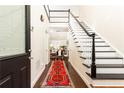 Grand foyer with dark hardwood floors, staircase with black accents, and beautiful runner at 4541 Wieuca Ne Rd, Atlanta, GA 30342