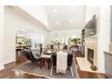 Bright living room with fireplace, TV, vaulted ceiling, and seamless flow to dining area at 4541 Wieuca Ne Rd, Atlanta, GA 30342