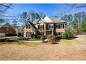 Beautiful brick home boasts mature trees, lush landscaping, and a well-maintained lawn at 305 Collegiate Dr, Powder Springs, GA 30127
