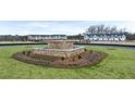 View of the new community entrance with manicured flowers in a landscaped roundabout at 452 Reflection Dr # 19, Stockbridge, GA 30281