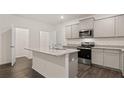 Modern kitchen features an island, granite countertops, stainless steel appliances and hardwood floors at 452 Reflection Dr # 19, Stockbridge, GA 30281