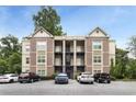 Apartment building with brick and beige facade, multiple balconies, and parking lot surrounded by mature trees at 1903 Anjaco Rd # 5, Atlanta, GA 30309