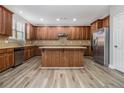 Modern kitchen with stainless steel appliances, wood cabinets, and a large center island at 4319 Alysheba Dr, Fairburn, GA 30213
