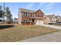 Charming two-story brick home features a two-car garage and well-maintained front lawn at 15 Mary Jane Ln, Covington, GA 30016