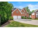 Brick home with well-manicured lawn, two-car garage, and neatly trimmed bushes at 370 Fairleaf Ct, Alpharetta, GA 30022
