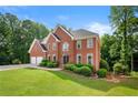 Traditional brick home features lush green lawn and meticulously maintained landscaping at 370 Fairleaf Ct, Alpharetta, GA 30022