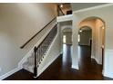 Spacious entryway featuring hardwood floors, a carpeted staircase, and arched doorways at 3818 Southfield Ct, Loganville, GA 30052