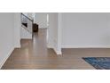 View of light filled entry and hallway with wood floors and staircase leading to upper level at 140 Worthing Ln, Fairburn, GA 30213