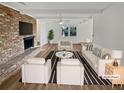 Bright living room with a brick fireplace, ceiling fan, neutral paint, and large windows, virtually staged at 5520 Morning Creek Cir, Atlanta, GA 30349