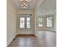 Bright entryway with wood floors, white trim, and a modern light fixture, leading into the living areas at 5533 Addison Woods Pl, Buford, GA 30518