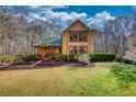 Charming two-story home with a landscaped yard, a green roof, and eye-catching windows at 5642 N Highway 212, Covington, GA 30016