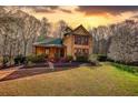 Charming two-story home with a landscaped yard, a green roof, and eye-catching windows at sunset at 5642 N Highway 212, Covington, GA 30016