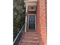 Inviting brick front porch with black front door and black hand railing at 11780 Wellsley Way, Alpharetta, GA 30005