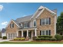Charming two-story brick home featuring black shutters and a well-manicured lawn at 4776 Trilogy Park Trl, Hoschton, GA 30548