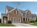 Charming two-story brick home featuring a gray garage door and a well-manicured lawn at 4776 Trilogy Park Trl, Hoschton, GA 30548