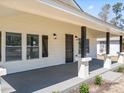 Close-up of the house showcasing a covered porch with square columns and new outdoor lighting at 1190 Dallas Hwy, Villa Rica, GA 30180