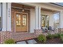 Inviting front porch featuring brick accents, stylish seating, and elegant architectural details at 2849 Parkridge Ne Dr, Brookhaven, GA 30319