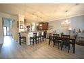 Open-concept dining area featuring modern light fixtures and bar seating adjacent to the kitchen at 9348 Lantana Trl, Jonesboro, GA 30238