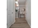 Hallway with wood-look floors, white trim, and neutral walls, leading to stairs and other rooms at 2871 Fareed, Douglasville, GA 30135