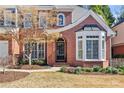 Charming brick home featuring a black front door, bay window, and manicured lawn at 3311 Fieldwood Se Dr, Smyrna, GA 30080