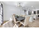 Stylish dining room featuring wainscoting, modern lighting, and an adjacent open kitchen at 4833 Glenwhite Dr, Duluth, GA 30096