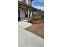 Landscaped front yard with walkway leading to a covered front porch of a cozy home with muted colors at 1986 Villa Spring Ct, Dacula, GA 30019