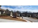 Residential street view with well-maintained homes, sidewalks, and trees in a suburban neighborhood at 1986 Villa Spring Ct, Dacula, GA 30019