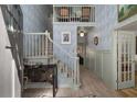 Grand foyer with blue wallpaper, wooden floors, staircase, and upper-level balcony showcasing the home's character at 2115 Azalea Dr, Roswell, GA 30075