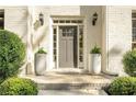 Inviting front entrance featuring a gray door, classic lanterns, and elegant planters enhancing the home's exterior at 2115 Azalea Dr, Roswell, GA 30075