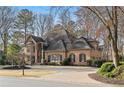 Elegant brick home with a circular driveway and meticulously landscaped front yard at 9185 Old Southwick Pass, Johns Creek, GA 30022
