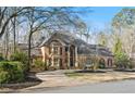 Expansive brick home with a grand entrance and a lush, green lawn at 9185 Old Southwick Pass, Johns Creek, GA 30022