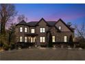 Dusk view of a brick home featuring manicured landscaping and warm exterior lighting at 2417 Siesta Ct, Marietta, GA 30062