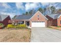 Charming brick home with a two-car garage, inviting front yard, and a well-maintained lawn at 499 Bellbrook Ln, Lawrenceville, GA 30045