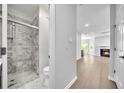 Modern bathroom featuring a gray-tiled shower with a glass door and updated fixtures and a fireplace in view at 609 Old Wheat Ne St, Atlanta, GA 30312