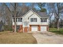 Traditional two-story home with white siding, brick accents, an attached two-car garage, and mature trees at 1542 Bogota Way, Jonesboro, GA 30236