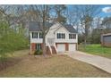 Traditional house featuring white siding, brick accents, an attached two-car garage, and mature trees at 1542 Bogota Way, Jonesboro, GA 30236