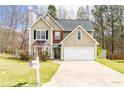 Two-story home with a two-car garage, showcasing a neat front lawn and trimmed bushes by the entrance at 3045 Arden Ridge Dr, Suwanee, GA 30024