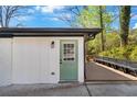 Exterior shot of a white brick home, with a green door and access to a wooden deck at 629 Moselle Sw Dr, Mableton, GA 30126