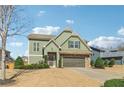 Inviting two-story home featuring green siding, stone details, and a double garage at 3255 Blackburn Dr, Cumming, GA 30040