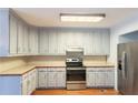 A kitchen with gray cabinets, stainless steel appliances and a wood floor at 5150 Rockford Ln, Stockbridge, GA 30281