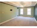 Spacious main bedroom featuring plush carpet, tray ceiling, and two bright windows at 5150 Rockford Ln, Stockbridge, GA 30281