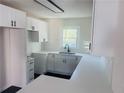 Modern kitchen featuring white cabinets, quartz countertops, tile backsplash, and stainless sink at 53 Springside Se Dr, Atlanta, GA 30354